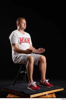 Louis  2 dressed grey shorts red sneakers sitting sports…